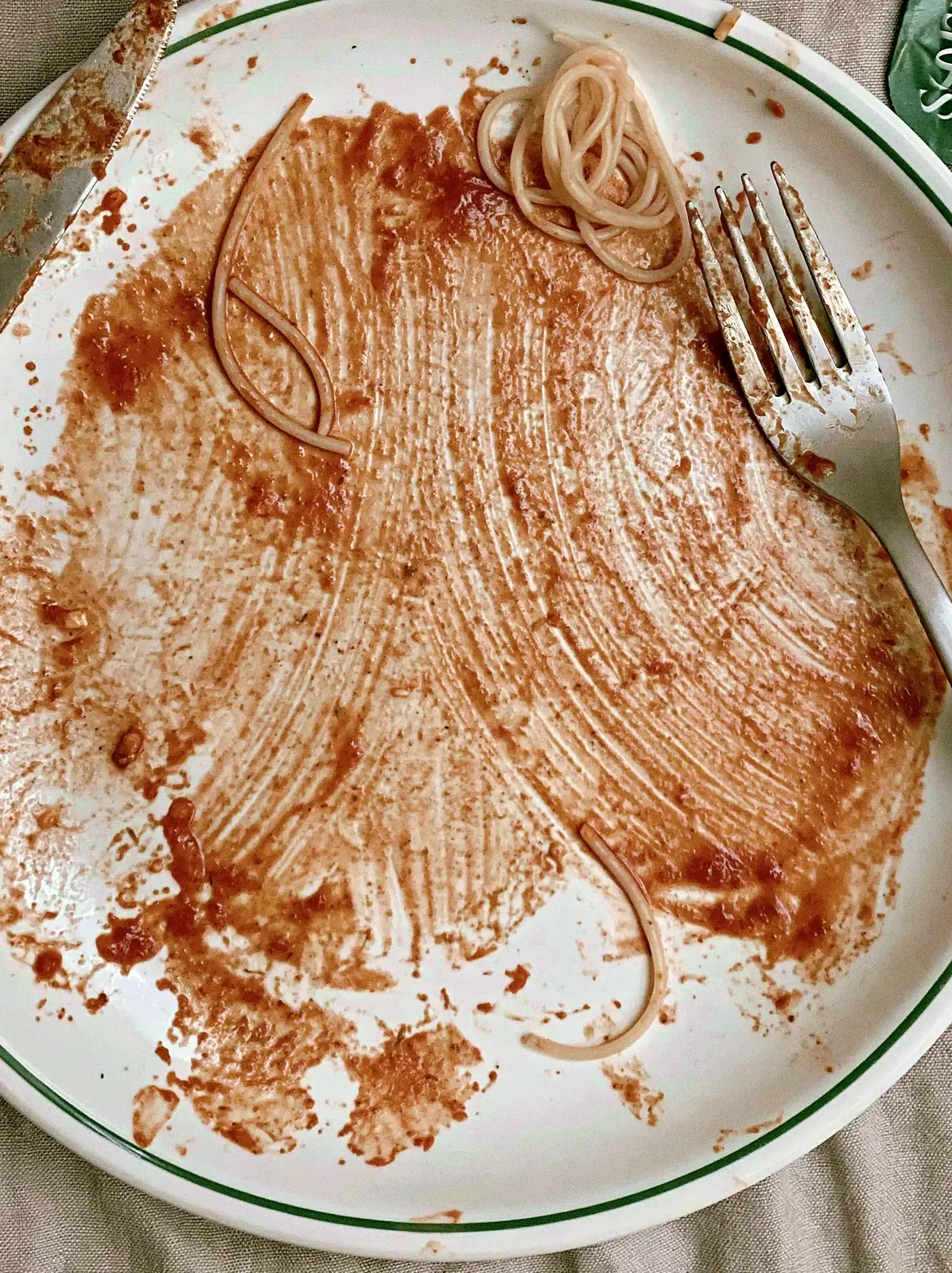 Assiette de pâtes presque terminée, vue de dessus au flash