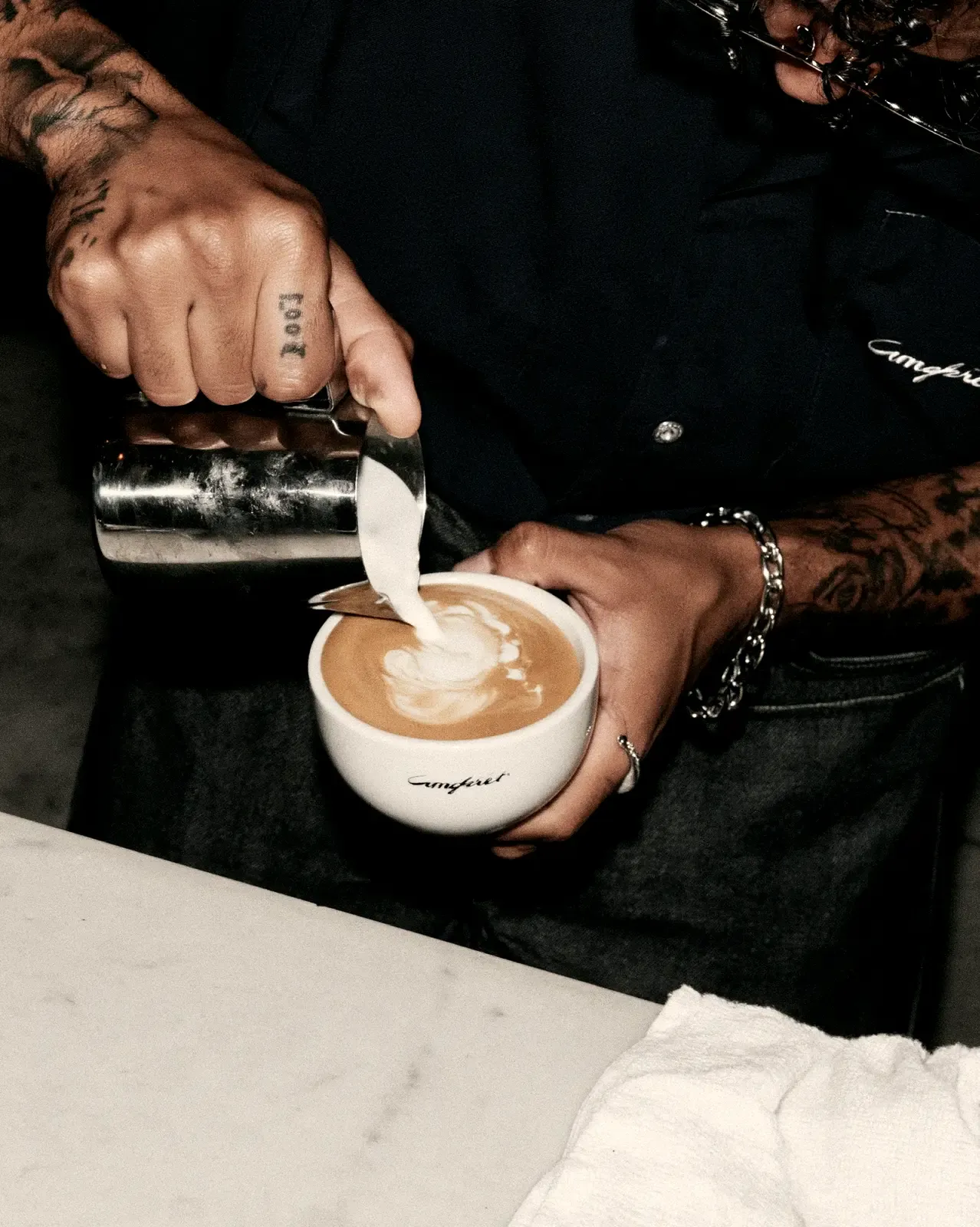 Barista qui dessine un latte art dans une tasse de café