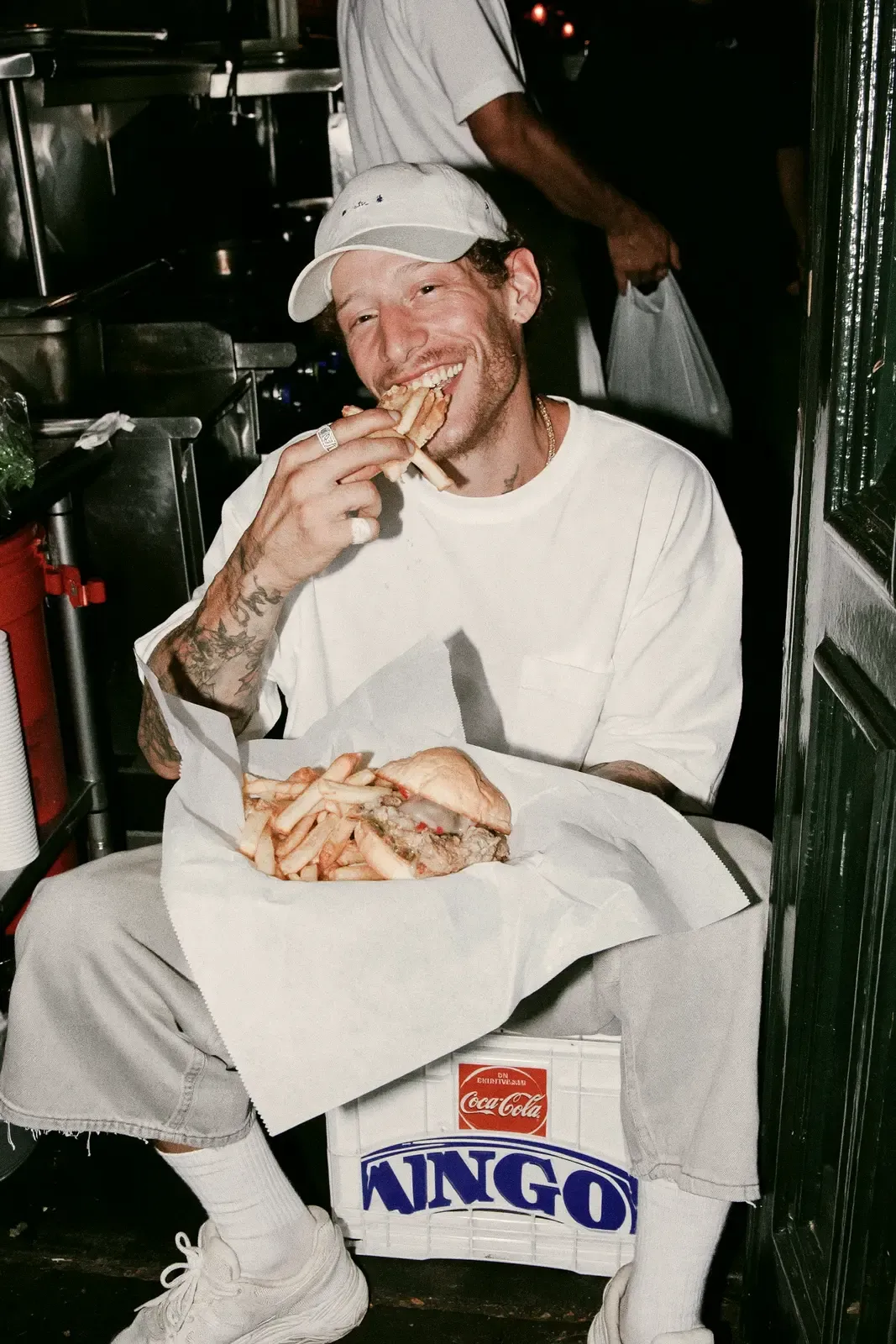 Cuisinier en pause qui mange un burger et des frites